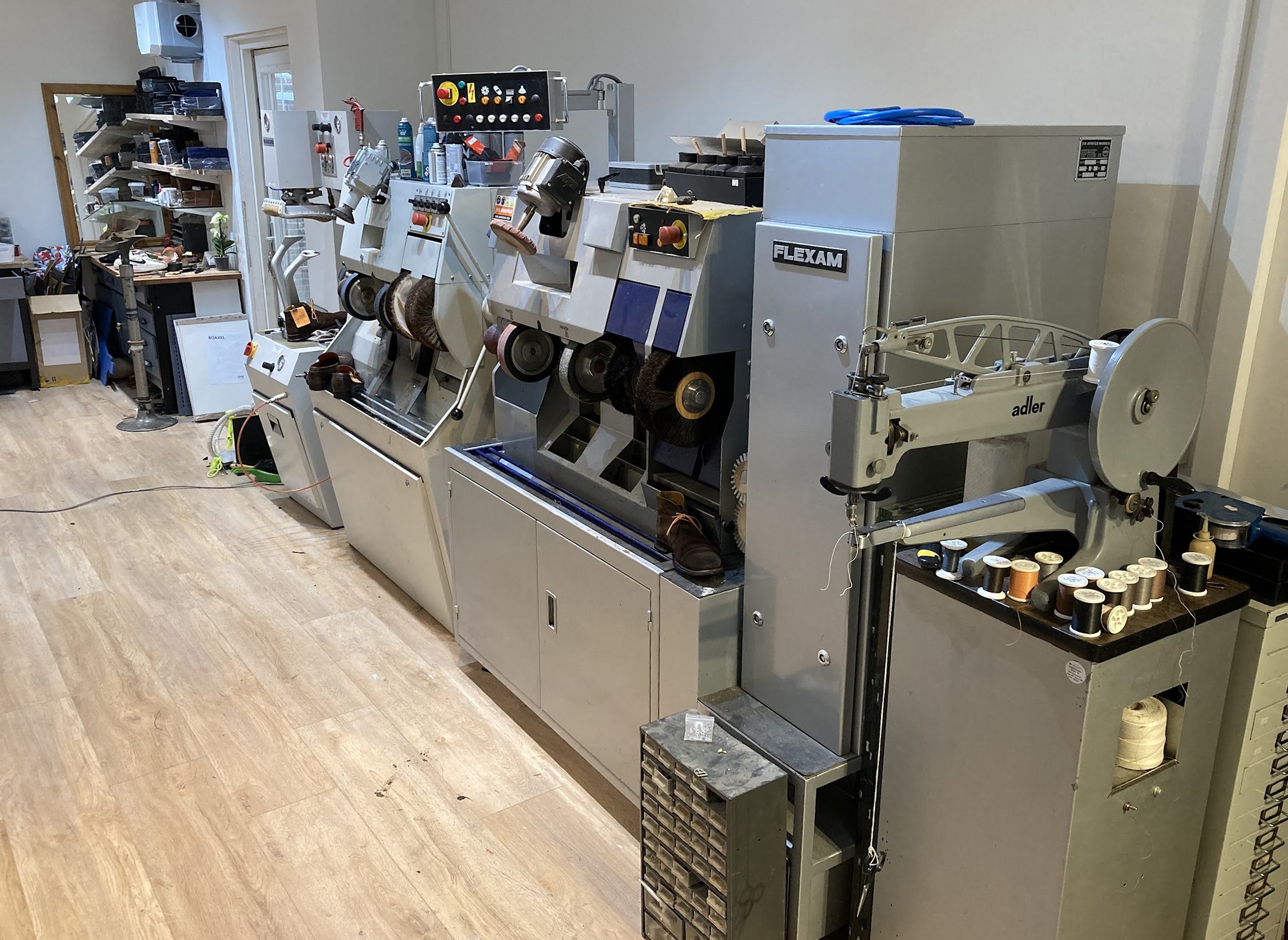 De werkplaats met de afwerkmachines voor schoenen en een naaimachine