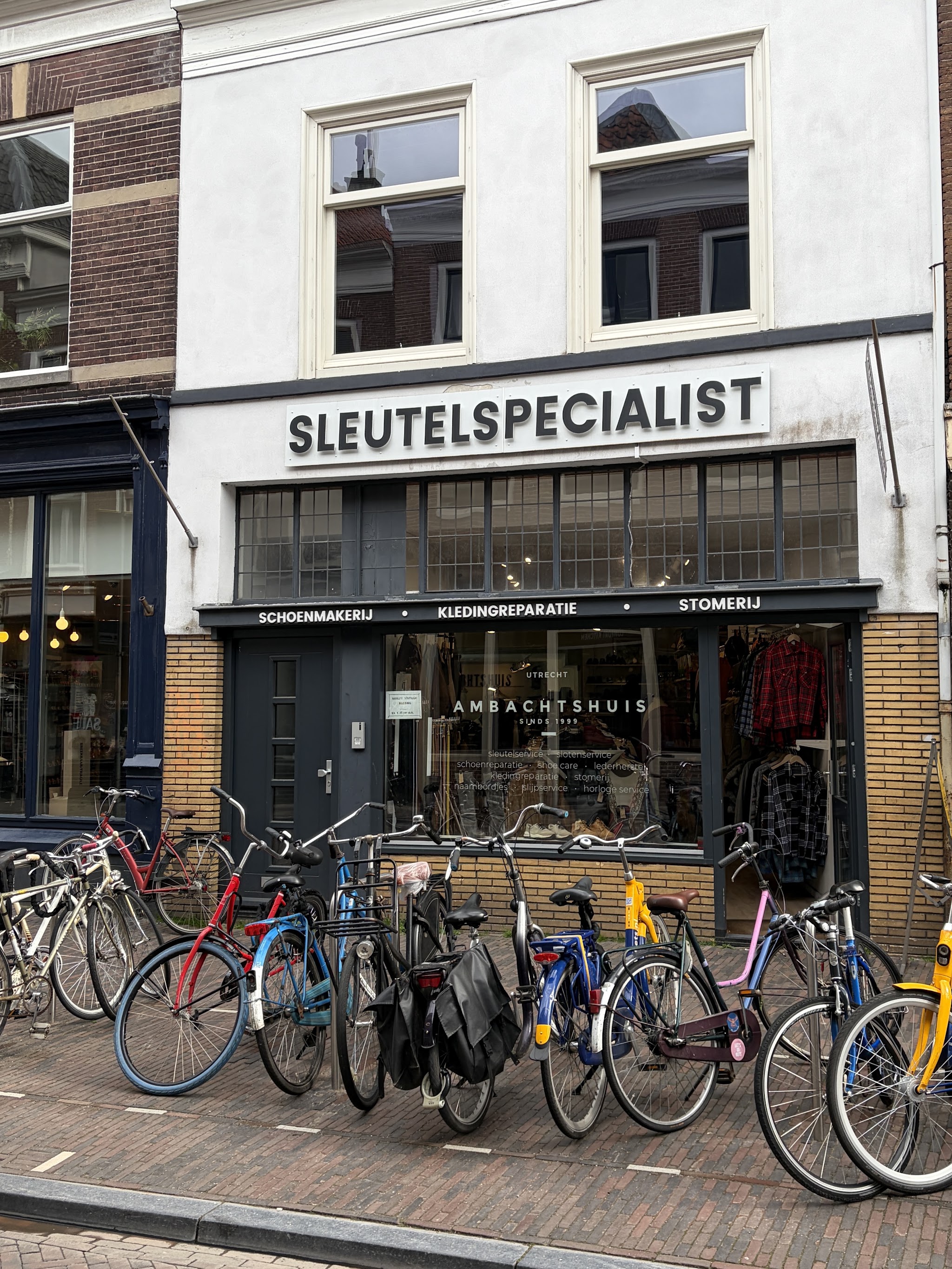 De winkel aan de Twijnstraat met het bord Sleutelspecialist en daaronder Schoenmakerij, Kledingreparatie, Stomerij