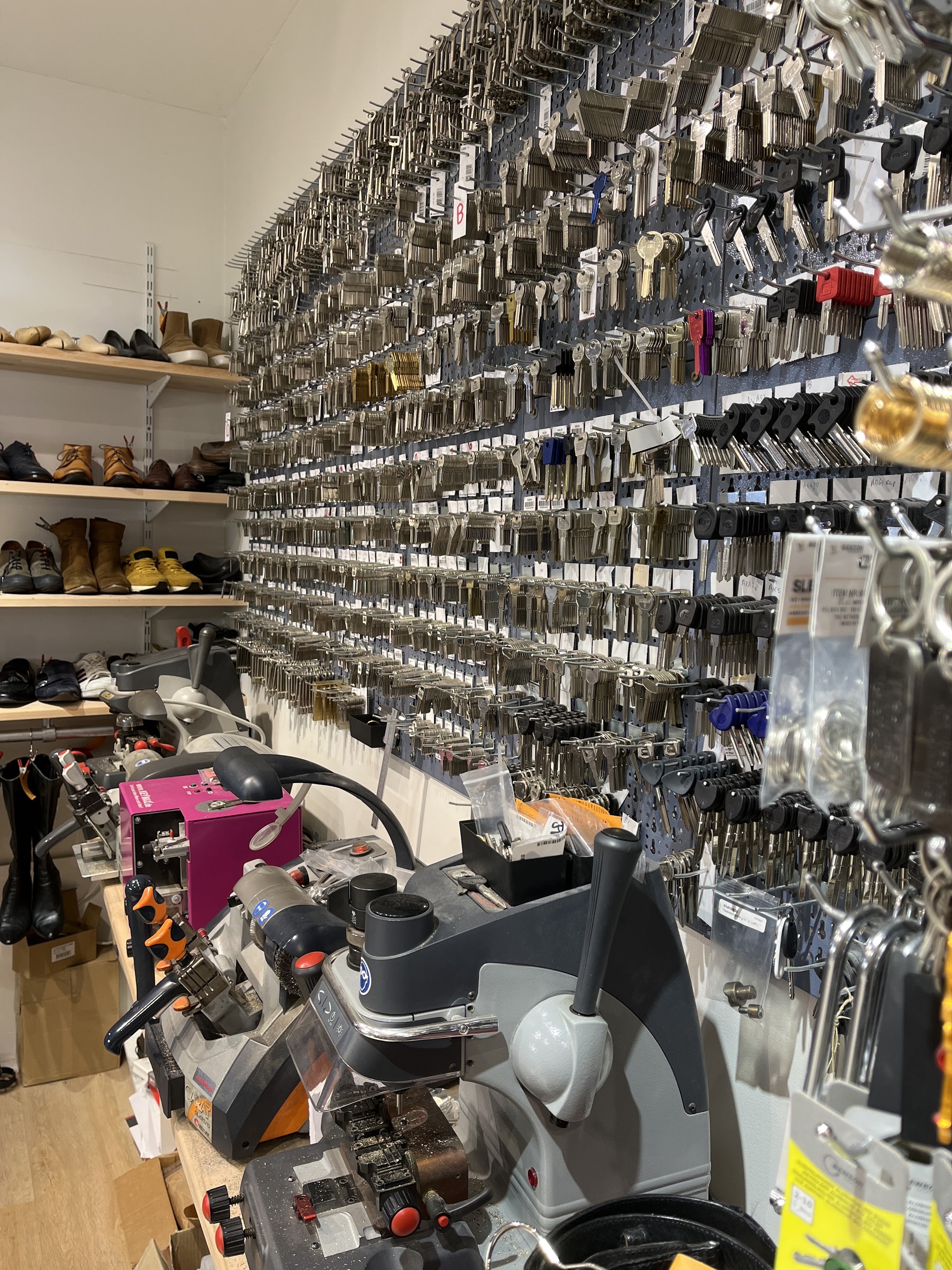 De sleutelwand en de sleutelmachine, met schoenen op de plank ernaast